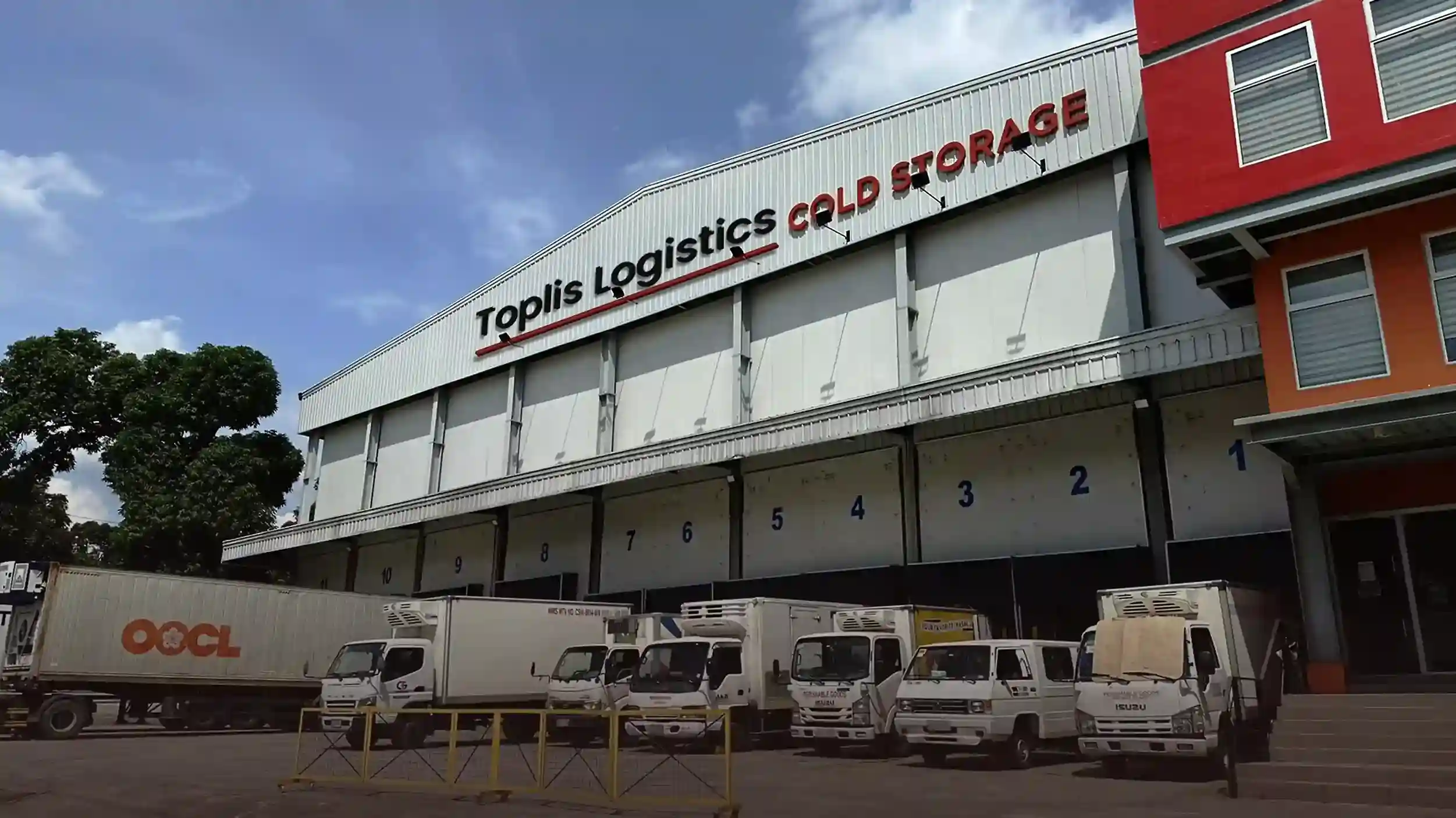 Toplis Logistics cold storage warehouse with multiple loading bays and delivery trucks for perishable goods distribution