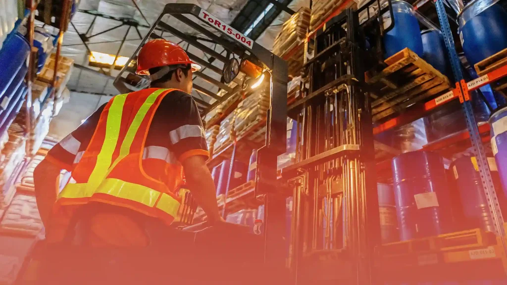 Toplis Logistics warehouse worker operating a forklift to move stored goods in an industrial facility.